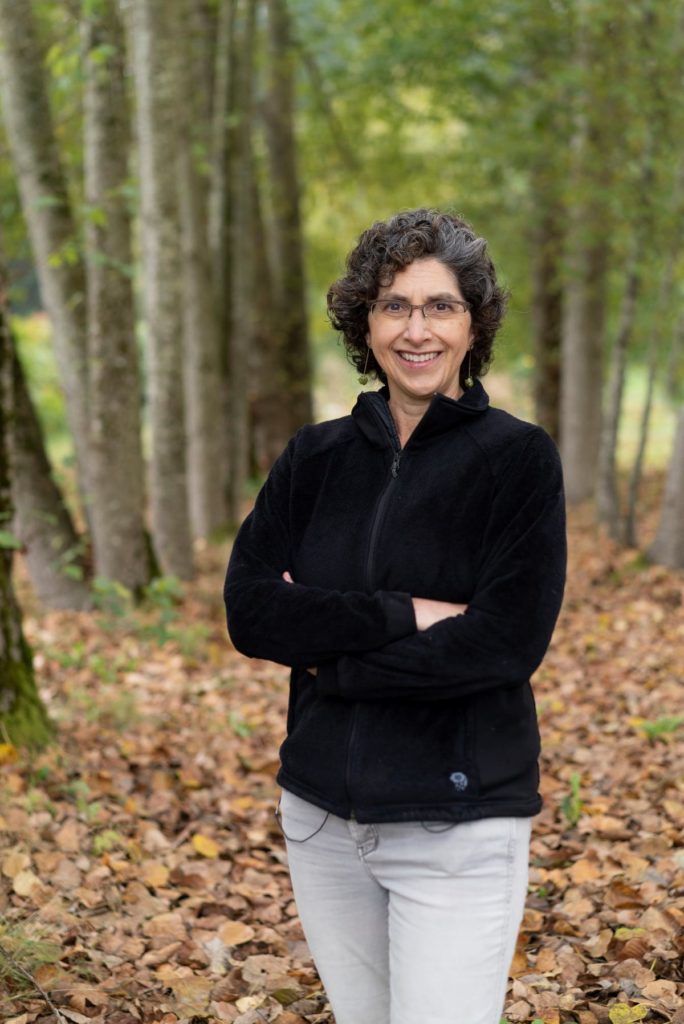 Photograph of Professor Claire Kremen, of The University of British Columbia, standing in woodland