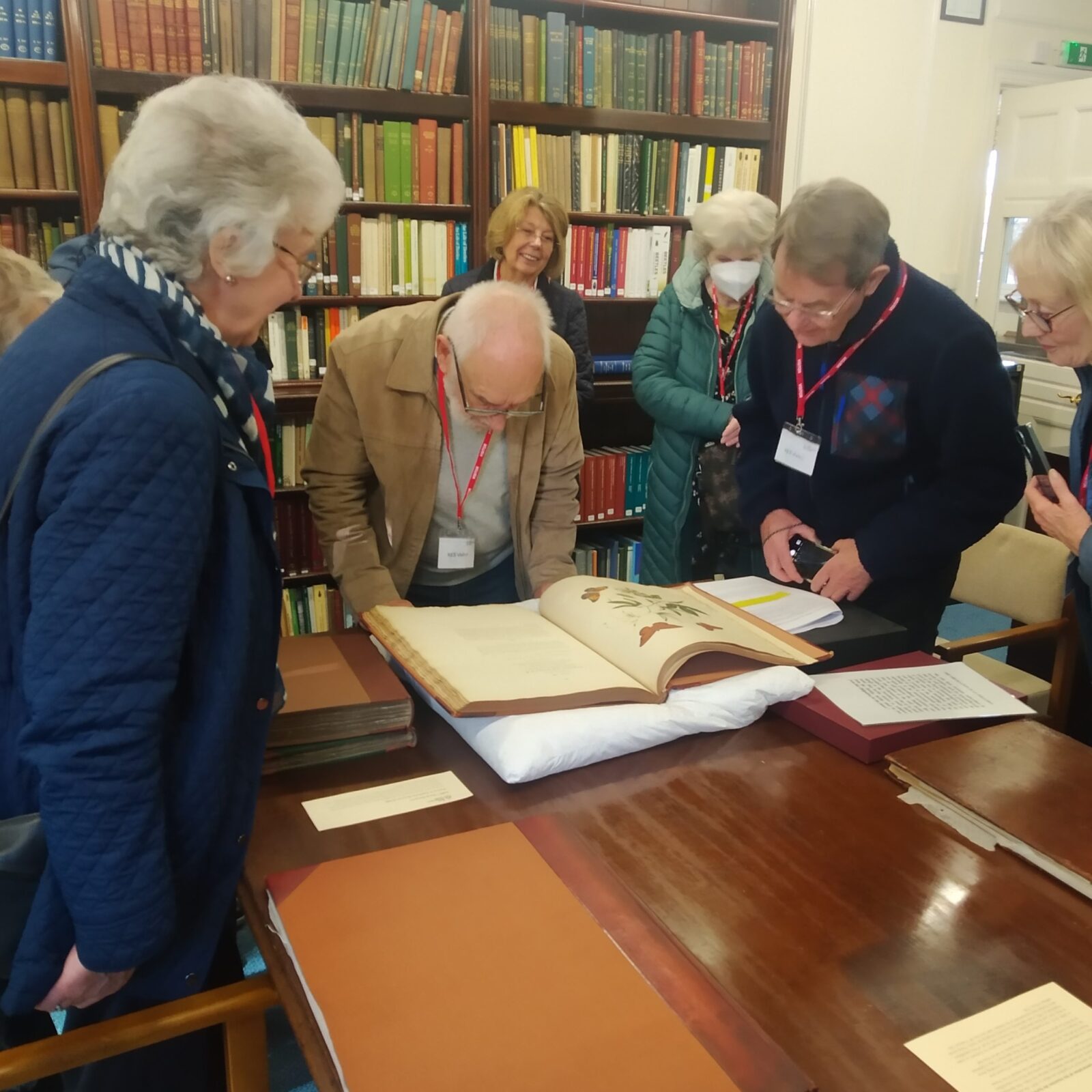 Harpenden Botanical Painting Group gathering around books at the Royal Entomological Society's library