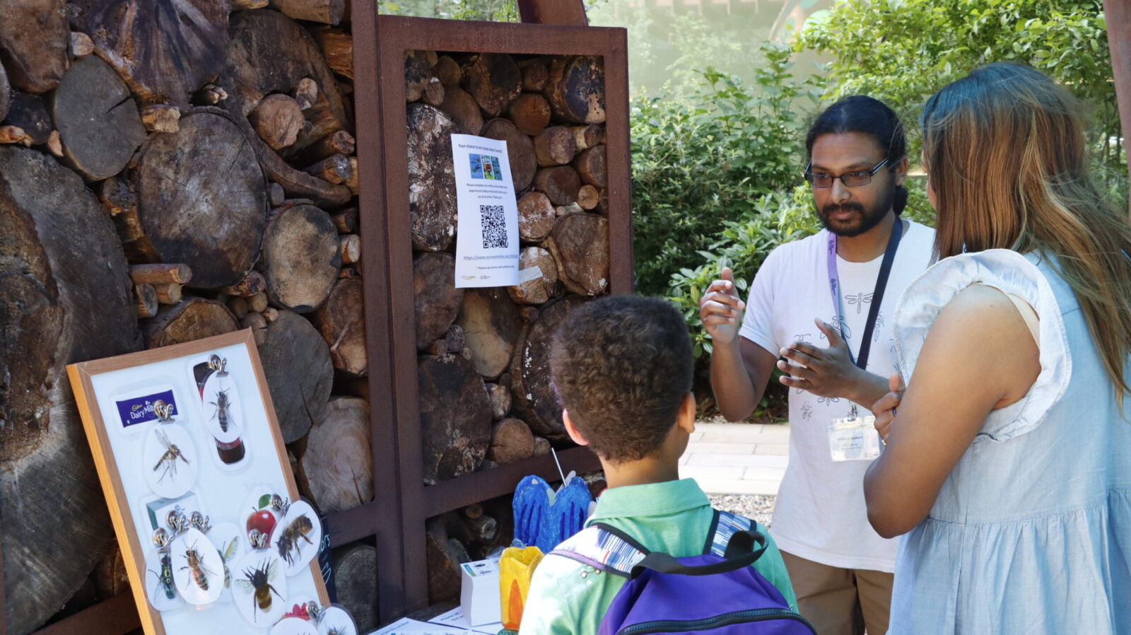 Joshua Moon Sammy speaking to a child about insects at the #RESGarden event during Insect Week 2025