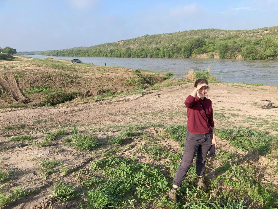 Maggie C. Vincent (lead author) in the field in Texas. Behind her is the Rio Grande and beyond is Mexico. 