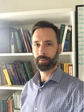 Philip Barton standing in front of a bookshelf