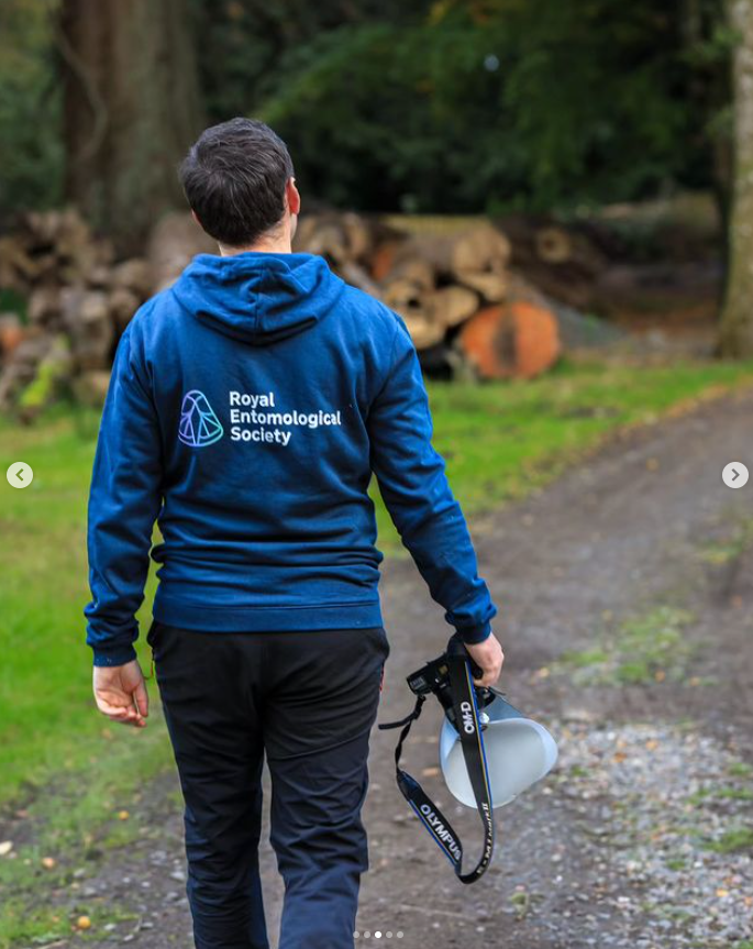 Award Winning Macro-photographer Paul Fraser wearing a navy blue hoodie with the Royal Entomological Society logo printed on his back