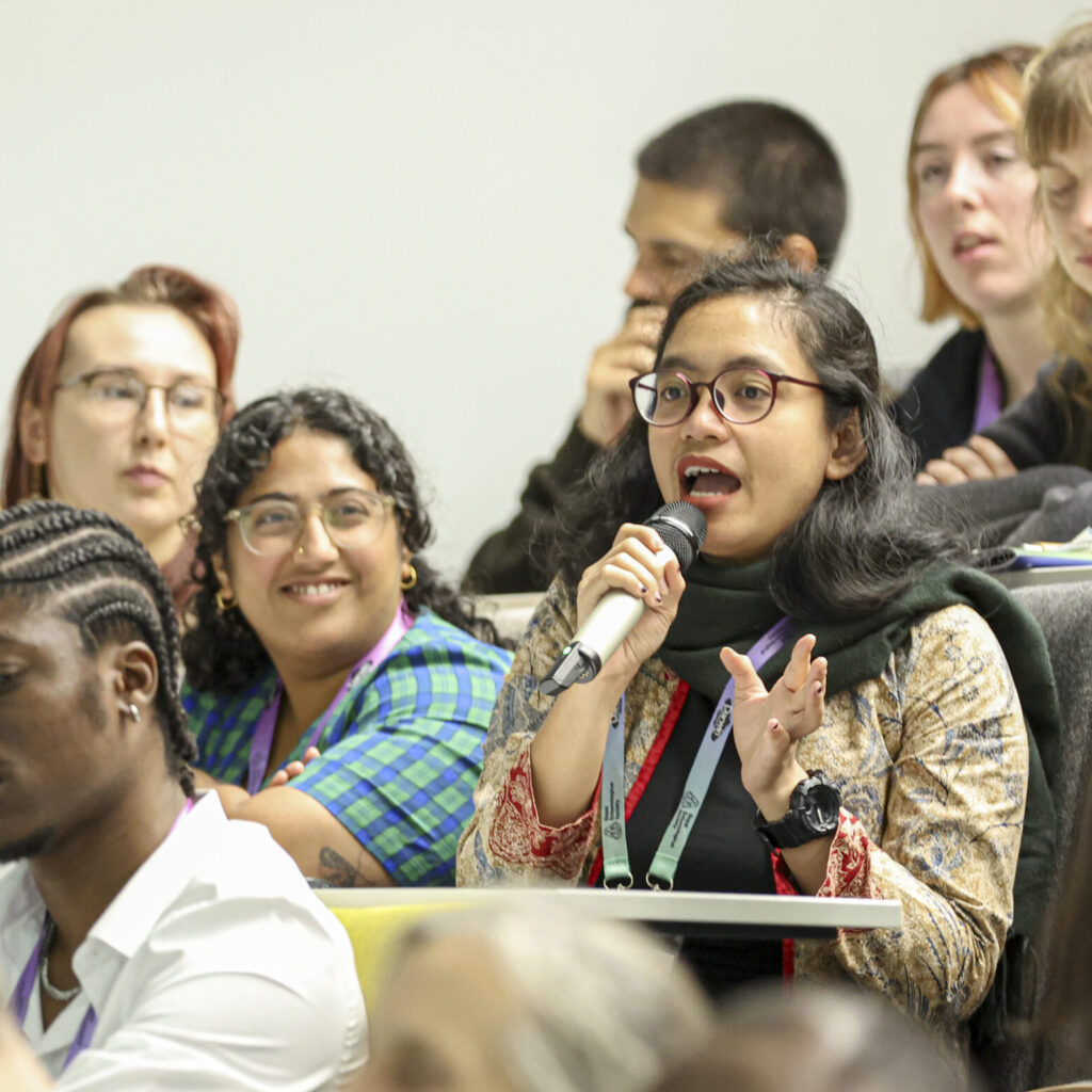 A delegate speaking and asking questions with a microphone - audience at Ento24