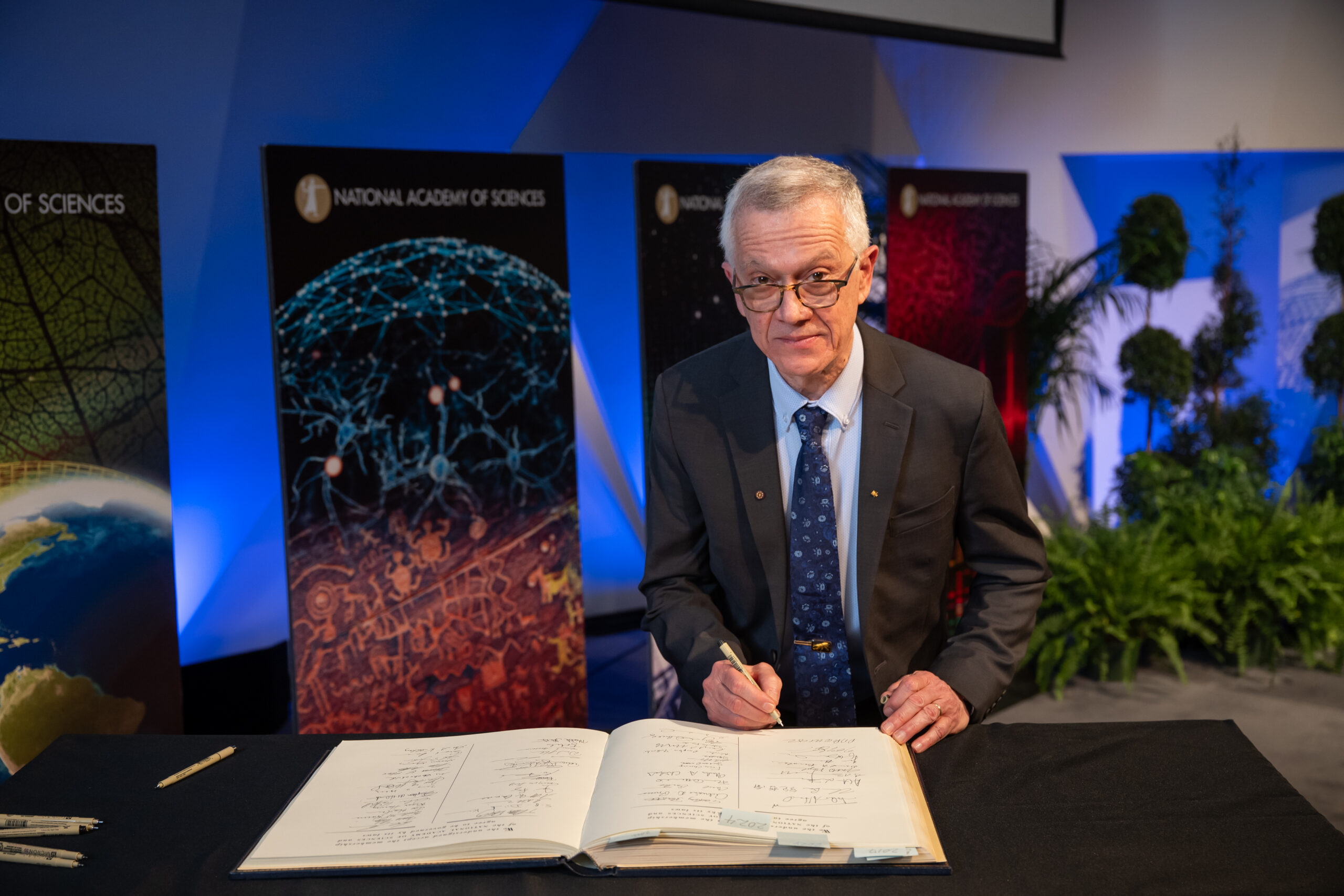 Walter signing the equivalent of the RES’s book of obligation at this Induction at the National Academy of Sciences (NAS). Credit: NAS; provided courtesy of Walter Leal.