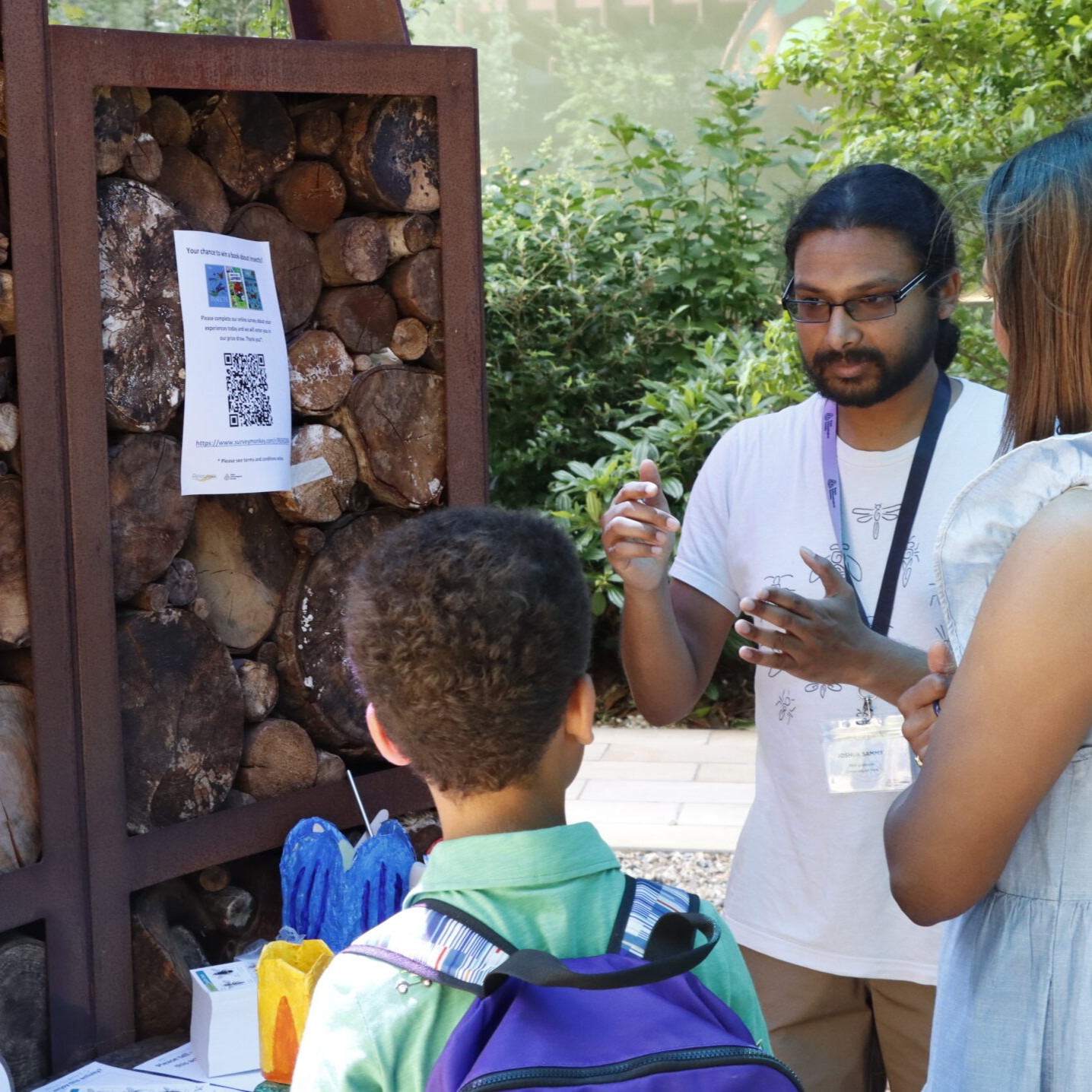 Joshua Moon Sammy speaking to a child about insects at the #RESGarden event during Insect Week 2025