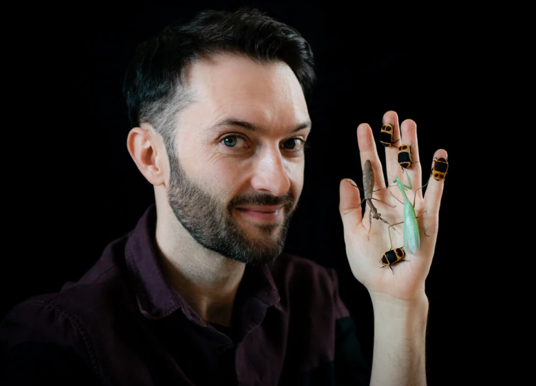 Tim Cockerill holding up insects in his hands