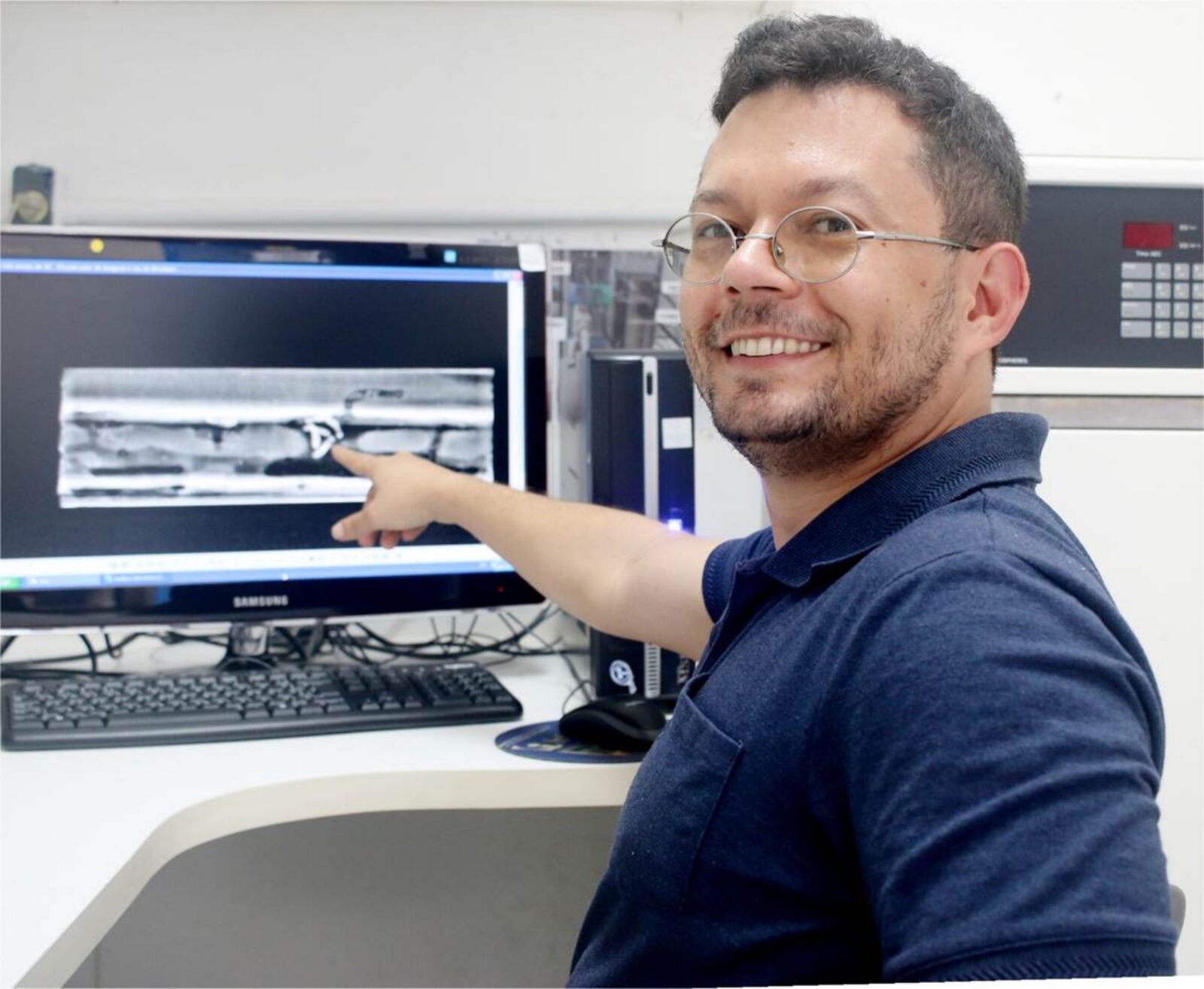 Image 2. Lirio Cosme presenting a radiograph of a wood piece, showing the internal tunnel networks and termite pseudergates. Photo Credit: Leo Turchen